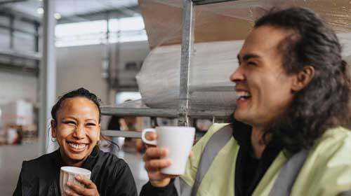 People drinking coffee in warehouse